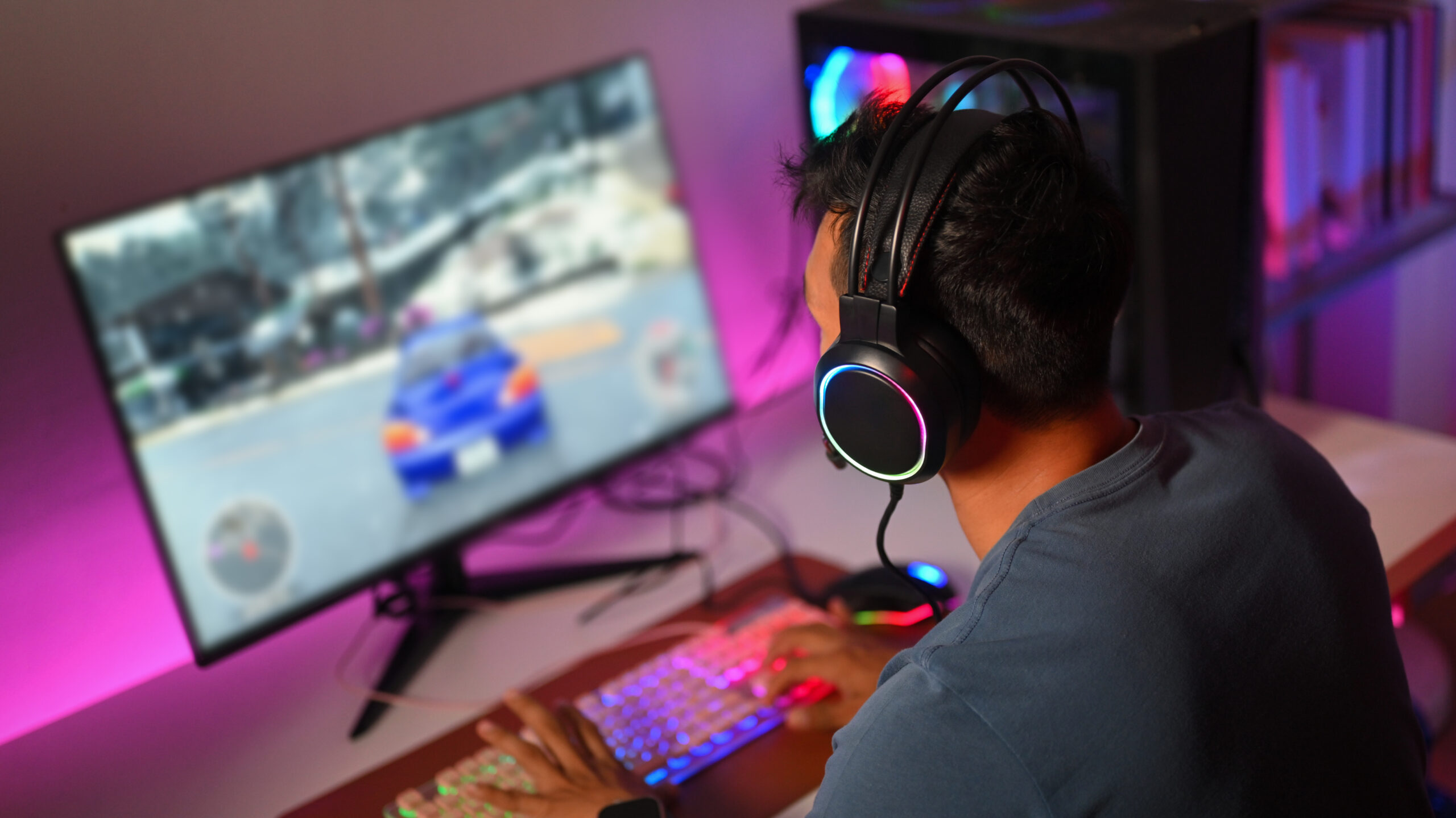 About Us Gamer wearing RGB gaming headset playing on PC at ZAT Gaming Store Faisalabad